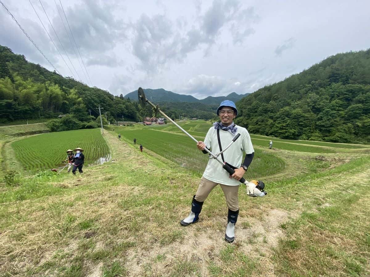 草刈り機を手に持ってやる気満々の編集部いしやん