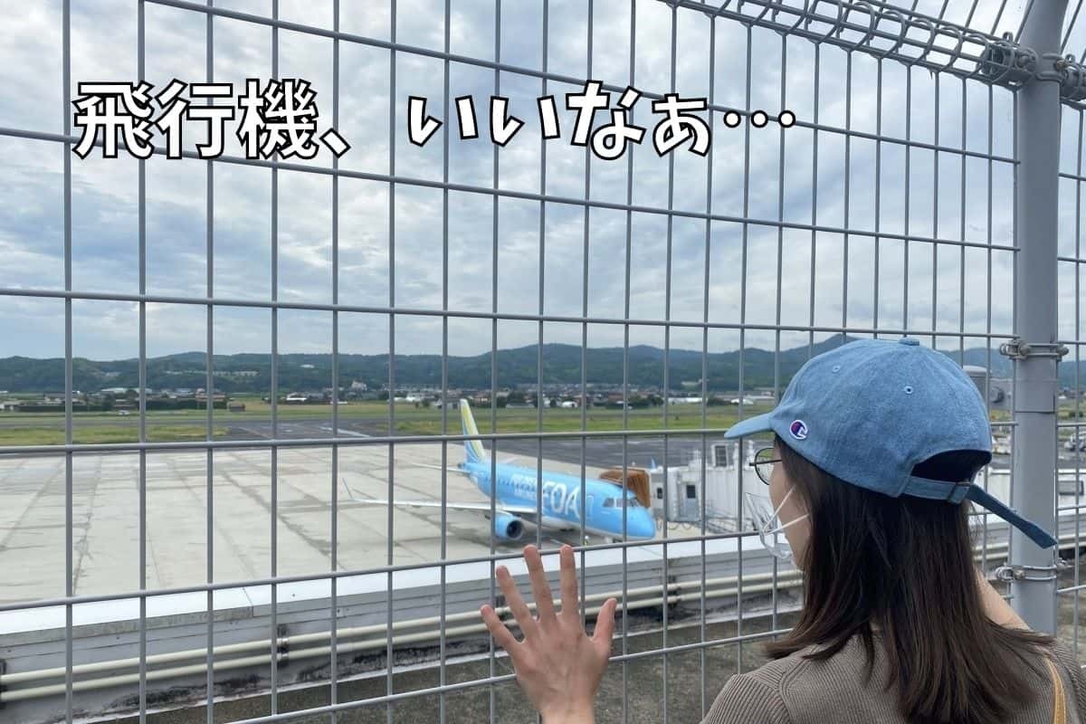 飛行機を見つめる編集部あつきち