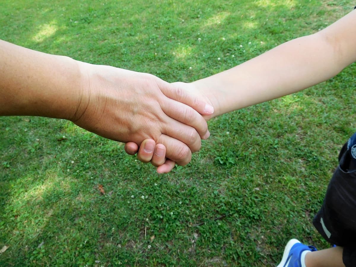 子どもと手を繋いで歩いているイメージ