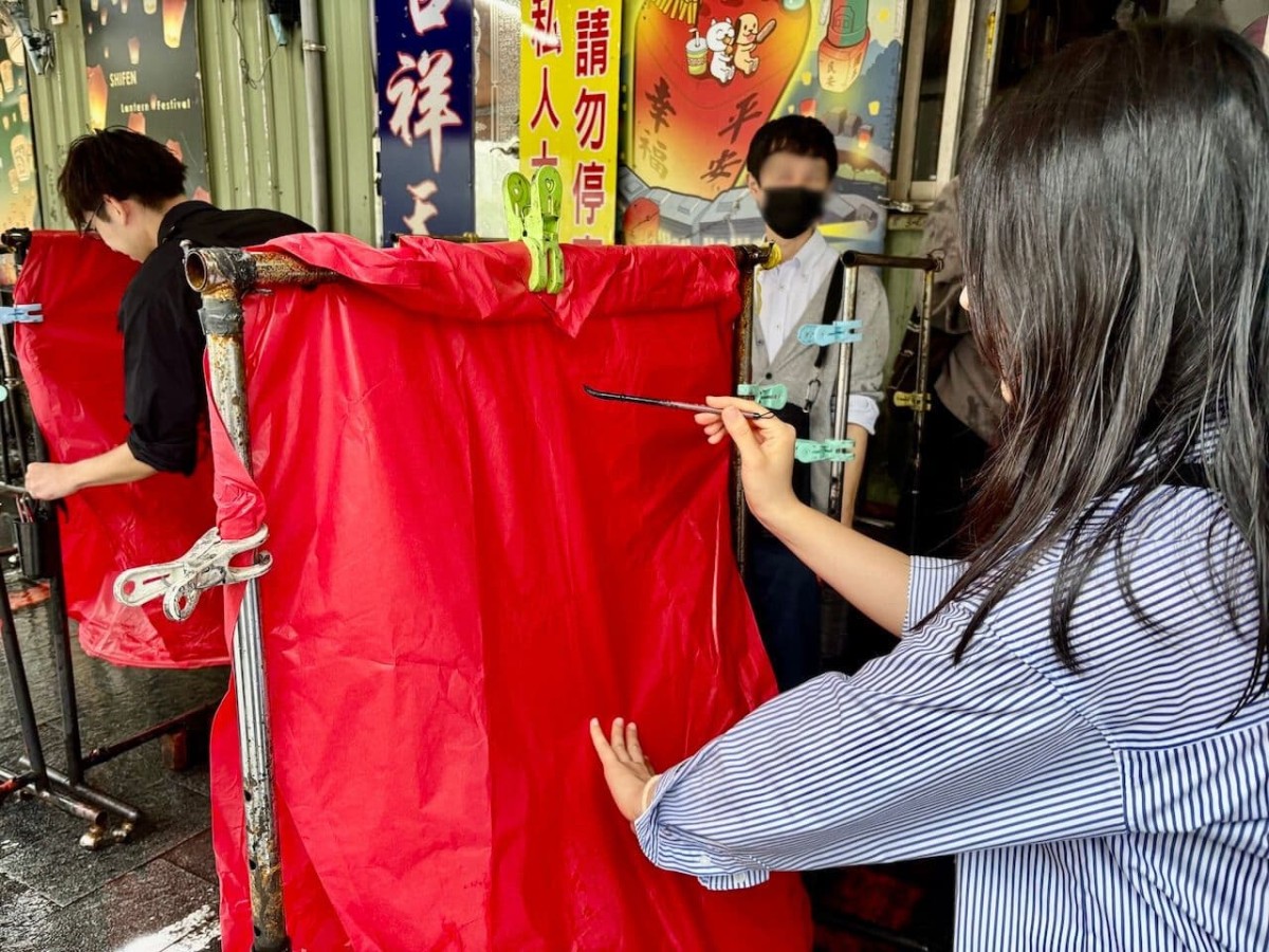 台湾の「十分老街」のランタンに願い事を書く様子。